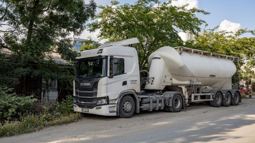 Camião-cisterna branco estacionado, usado no transporte de mercadorias perigosas